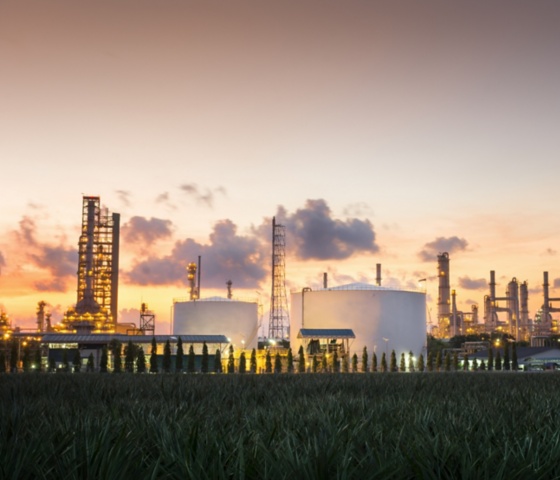 a factory with a sunset sky