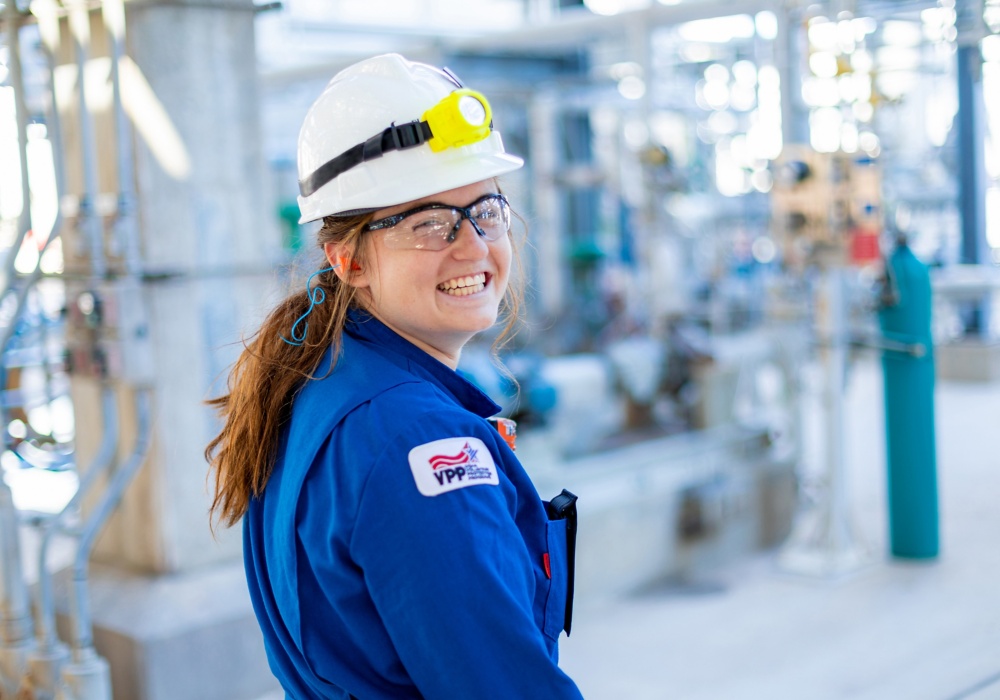 a woman wearing a hard hat and blue shirt