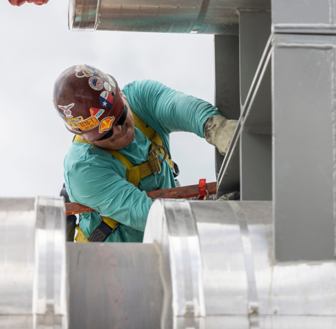 a man wearing a helmet and holding a ladder