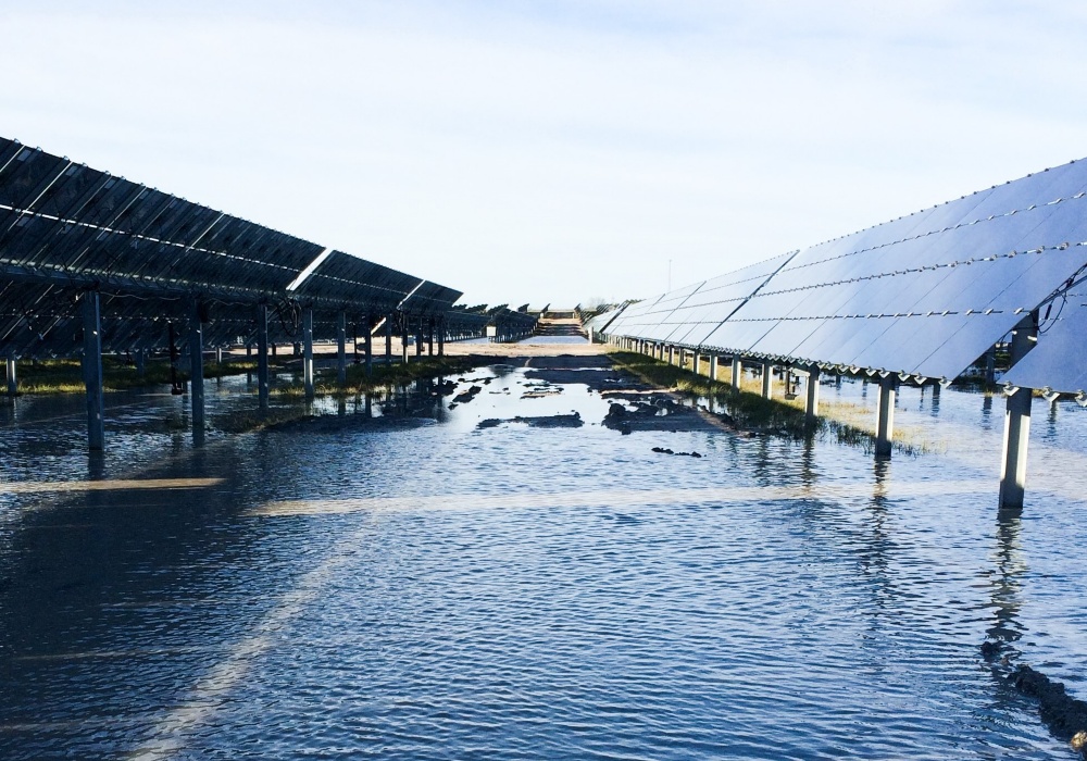 a flooded road with solar panels