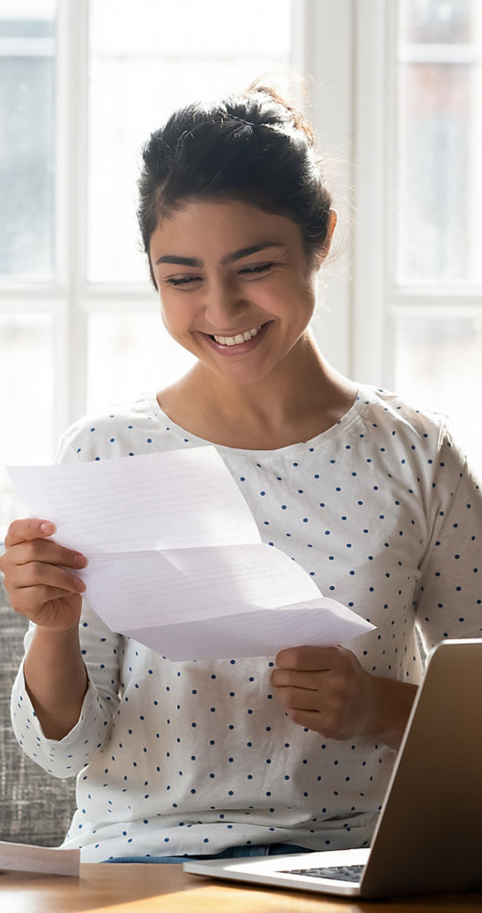 a woman sitting on a couch holding papers