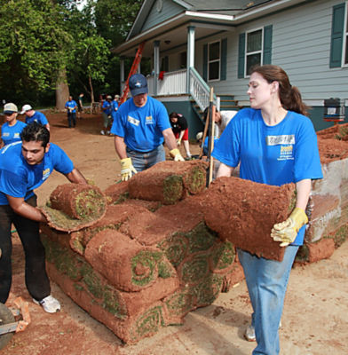 a group of people rolling grass rolls