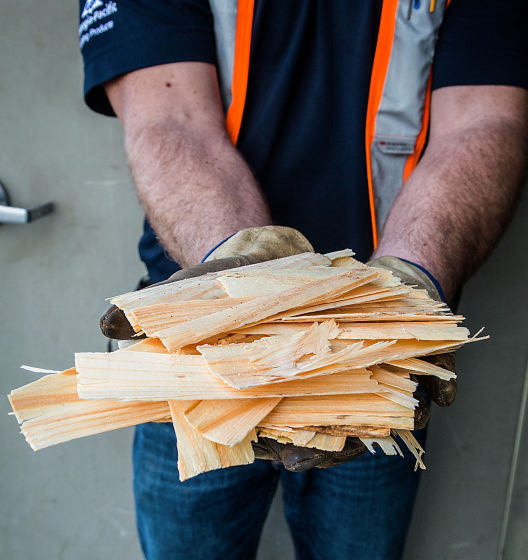 a person holding a pile of wood