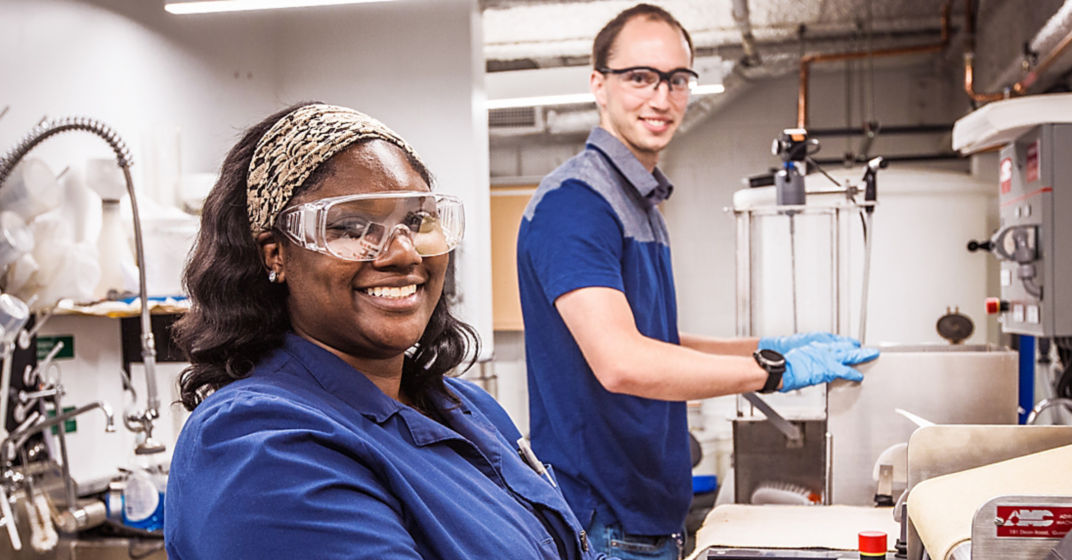 a woman wearing blue and safety glasses and gloves