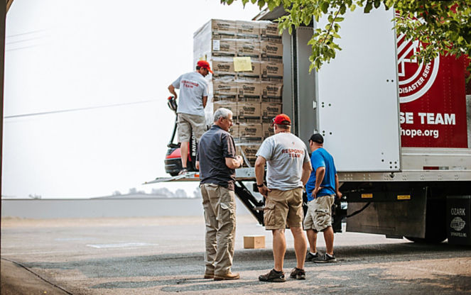 a group of men loading boxes into a truck