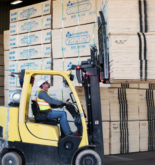 a man driving a forklift in a warehouse
