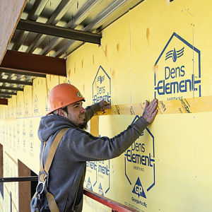 a man in a hard hat using a tape measure