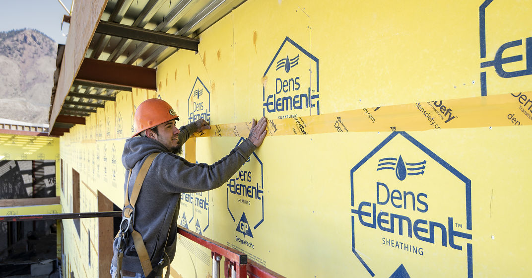 a man in a hard hat using a tape measure