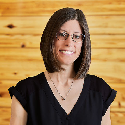 a woman wearing glasses and a black shirt