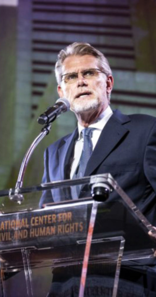 a man standing at a podium with a microphone