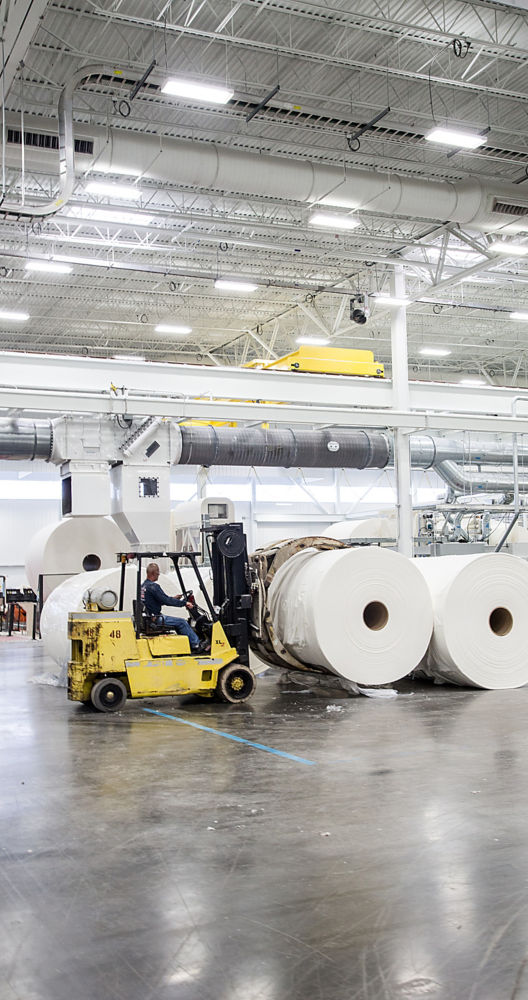a man driving a forklift in a factory