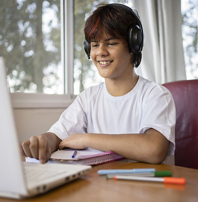 a young man wearing headphones and using a laptop