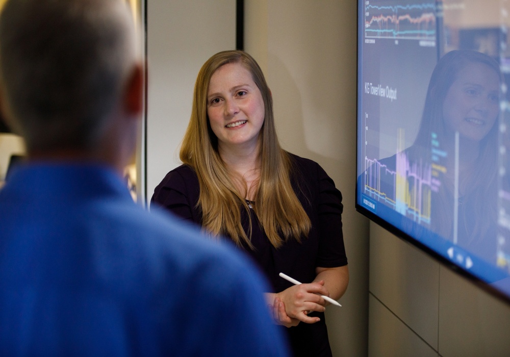 a woman standing in front of a screen