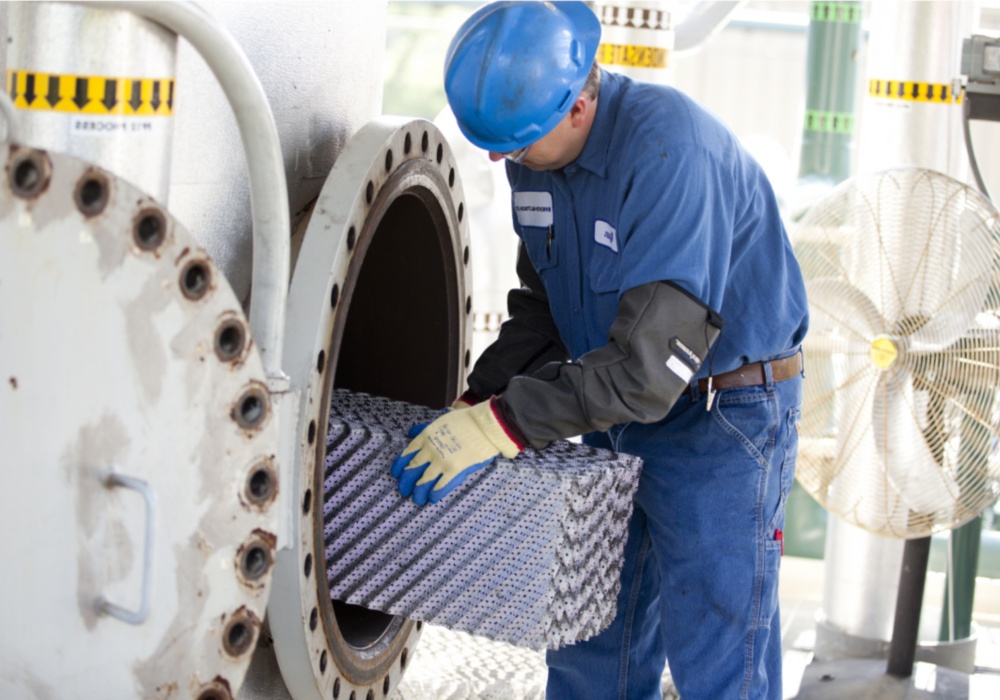 a man wearing blue hard hat and gloves