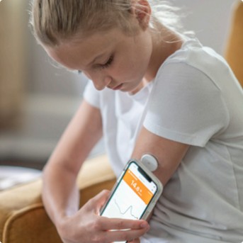 a girl using a device to check her blood pressure