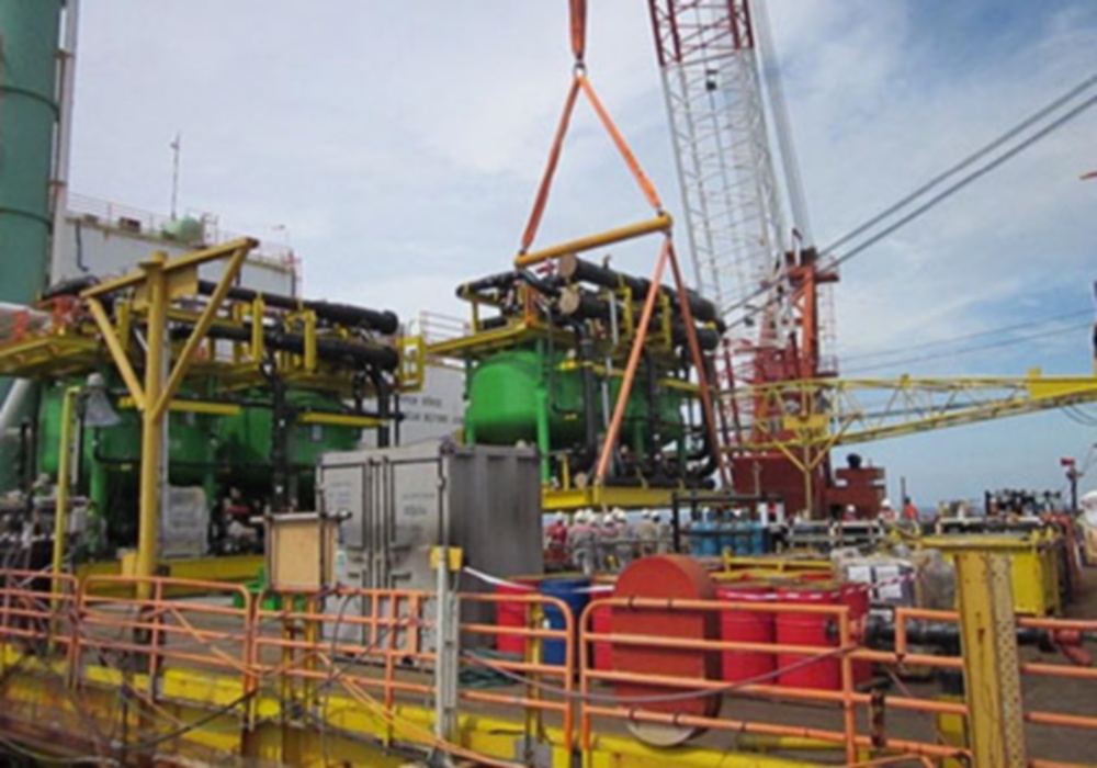 a crane lifting a large green machine