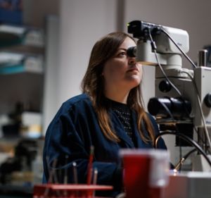 a woman looking through a microscope