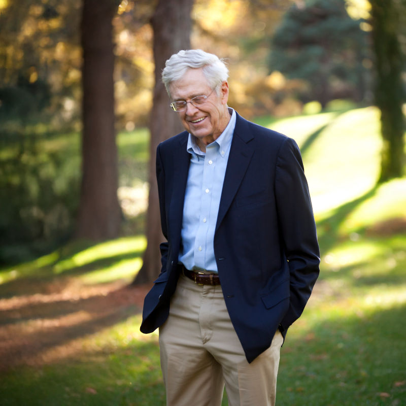 a man in a suit standing in a park