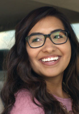 a woman wearing glasses smiling