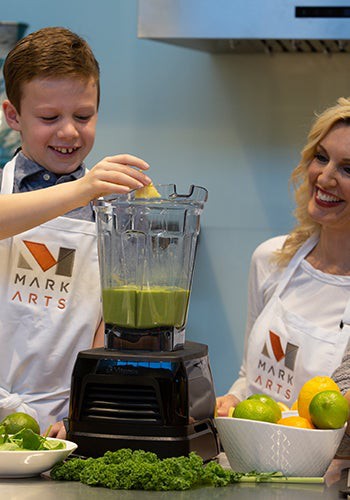 a boy and woman making a smoothie