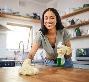 a woman cleaning a kitchen counter