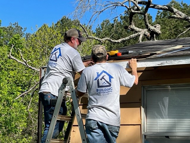 Georgia-Pacific’s Bruce Thompson and Lee Tamez repair a roof as part of the Operation Clean Sweep program.