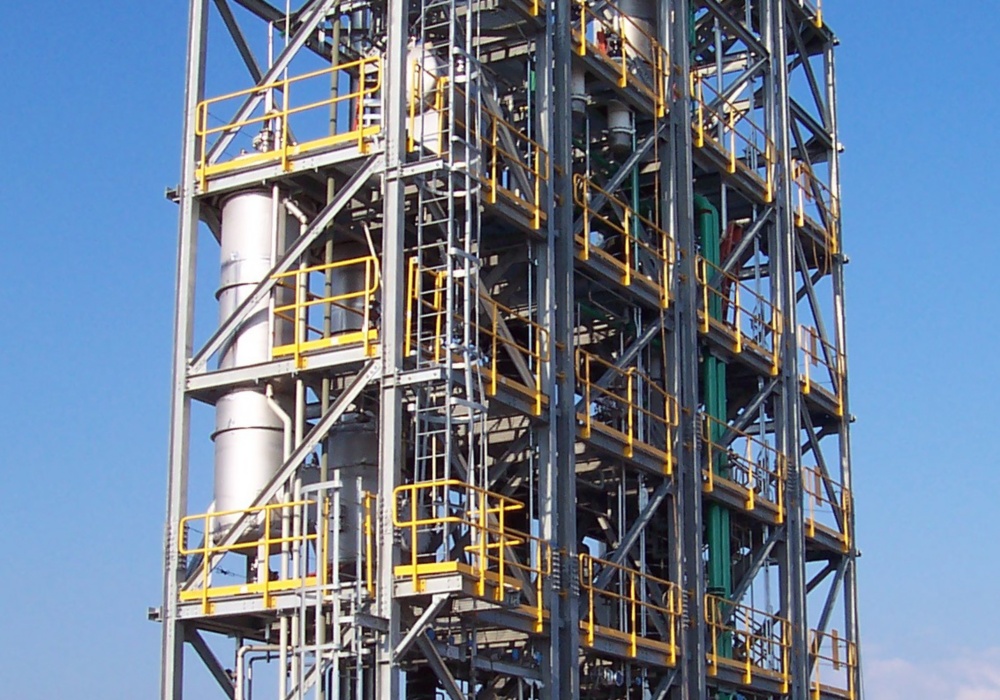 a large metal tower with yellow and gray scaffolding