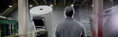 a man standing next to a large roll of paper