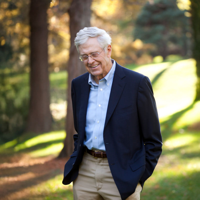 a man in a suit standing in a park