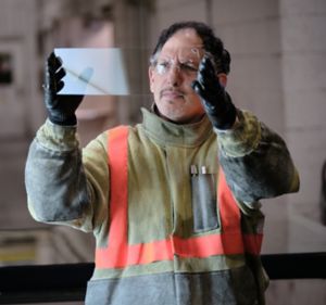 a man wearing safety gear and gloves holding a transparent sheet