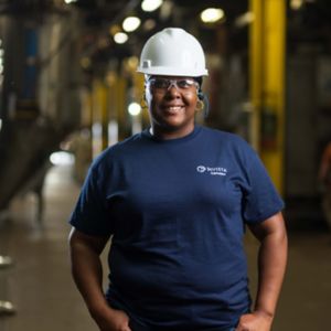 a woman wearing a hard hat and glasses
