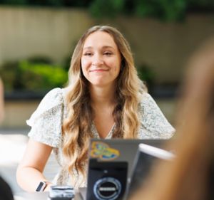 a woman smiling at a table