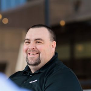 a man smiling and talking to another man