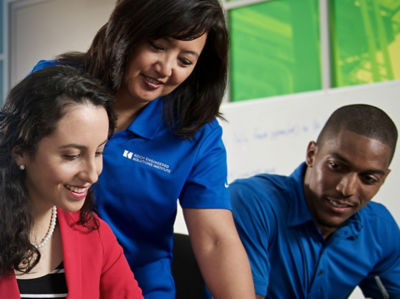 a group of people looking at a laptop