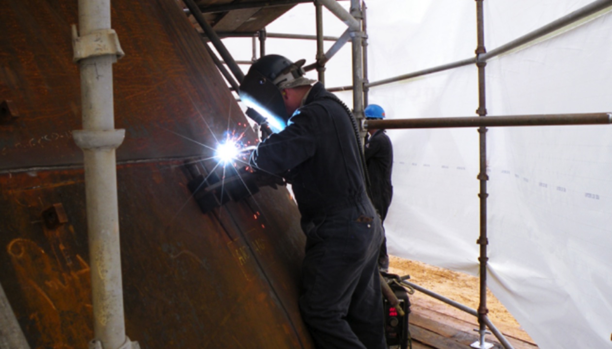 a man welding a large piece of metal