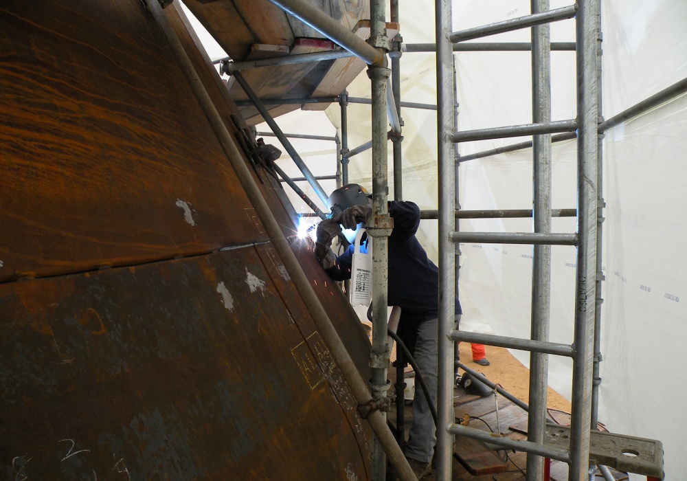 a man welding a large piece of metal